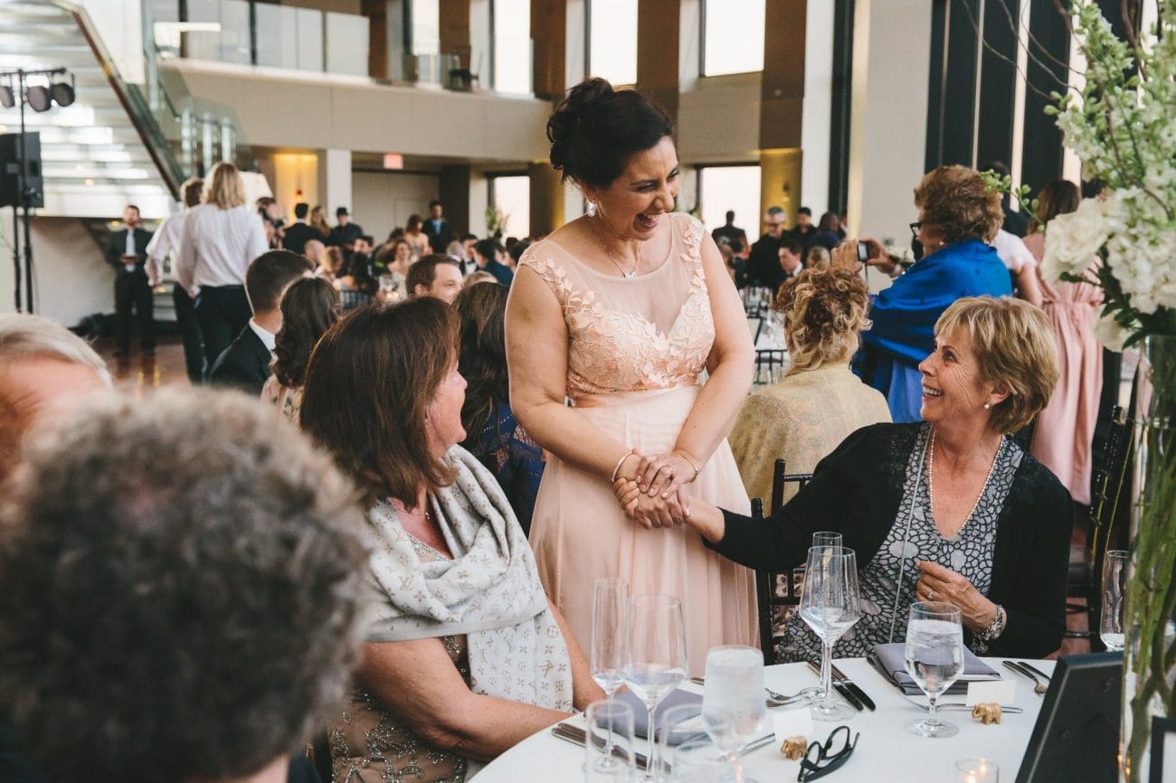 A documentary photograph of guests talking during a state room wedding reception in Boston, Massachusetts