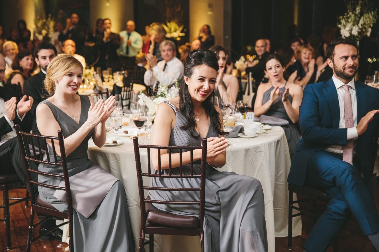A documentary photograph of guests applauding the wedding speeches at a State Room Wedding