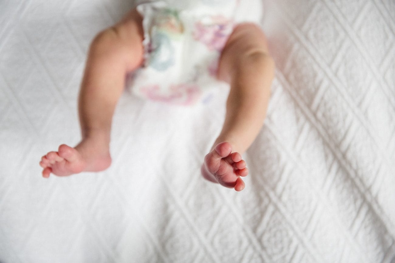 A lifestyle portrait of a newborn babies feet during an in home newborn session in Boston, Massachusetts