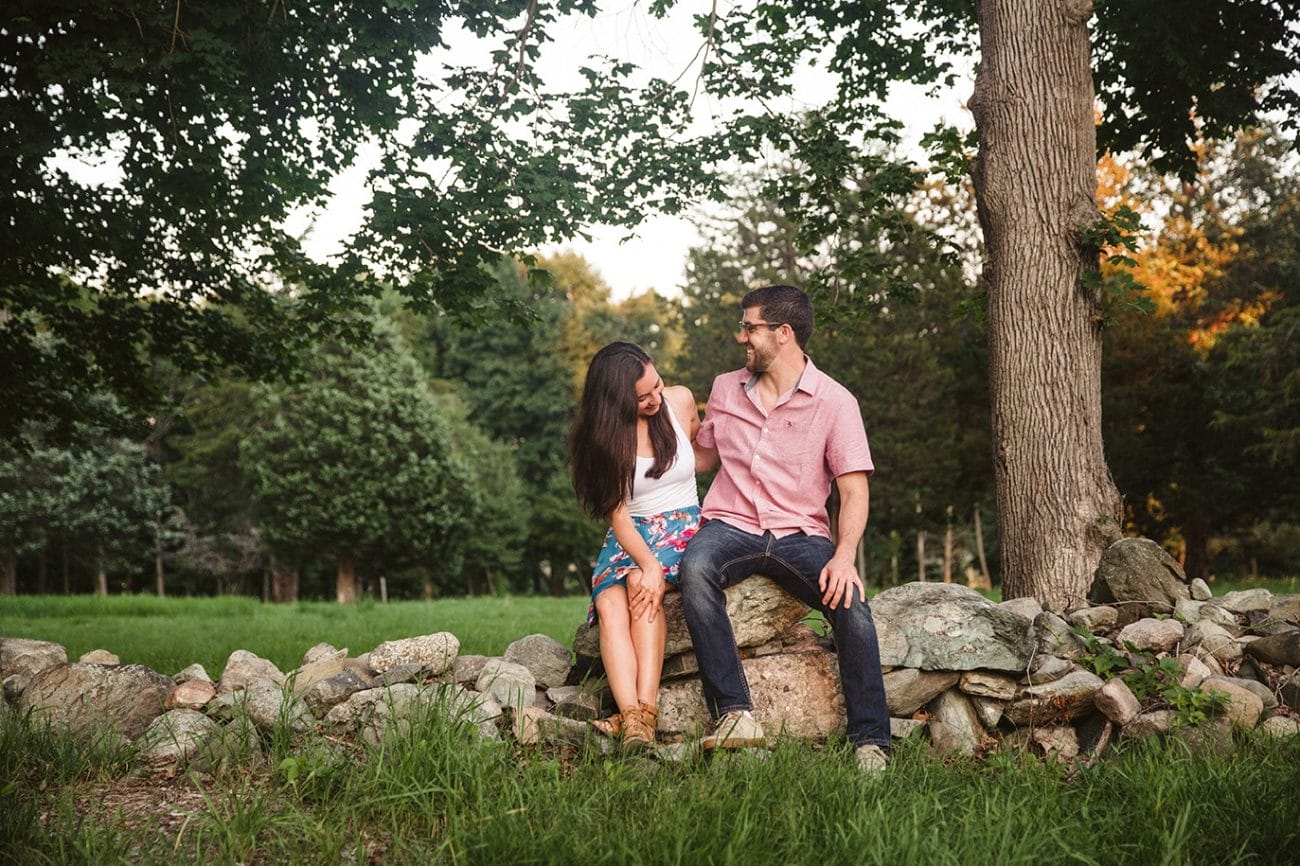 A documentary photograph of a couple laughing together during their World's End Engagement Session in Hingham, Massachusetts