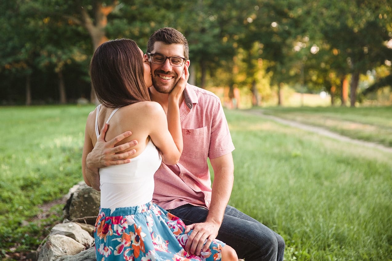 A documentary photograph a couple kissing and laughing during their World's End engagement session in Hingham, Massachusetts