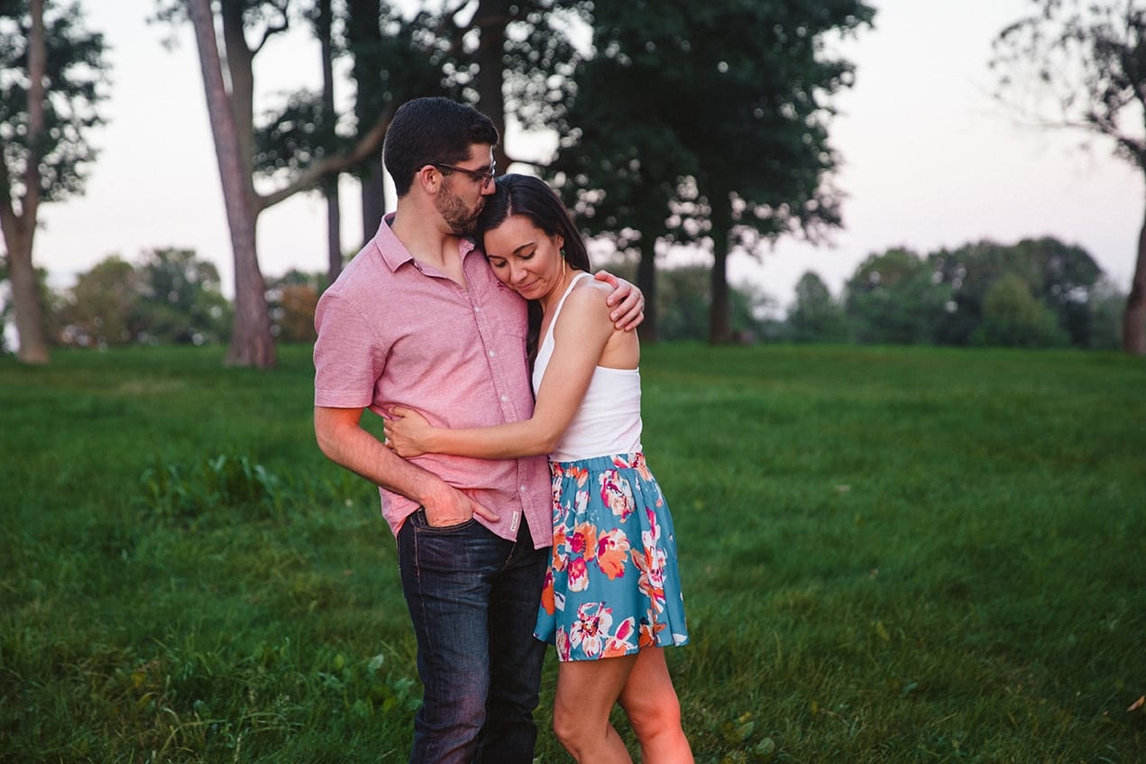 A documentary photograph of a couple kissing and hugging during their World's End engagement session in Hingham, Massachusetts