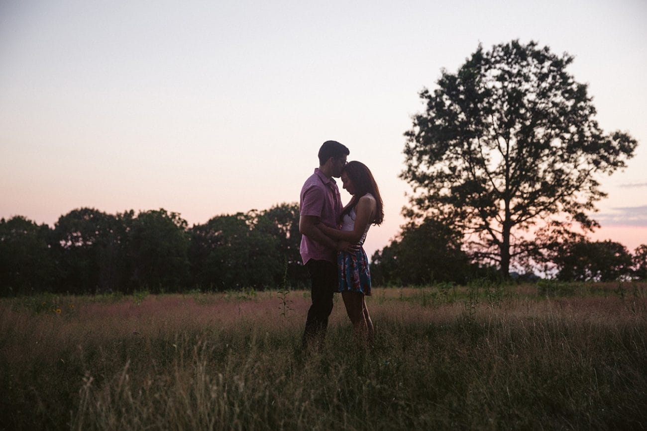 A couple kiss during their documentary engagement session at the World's End in Hingham, Massachusetts