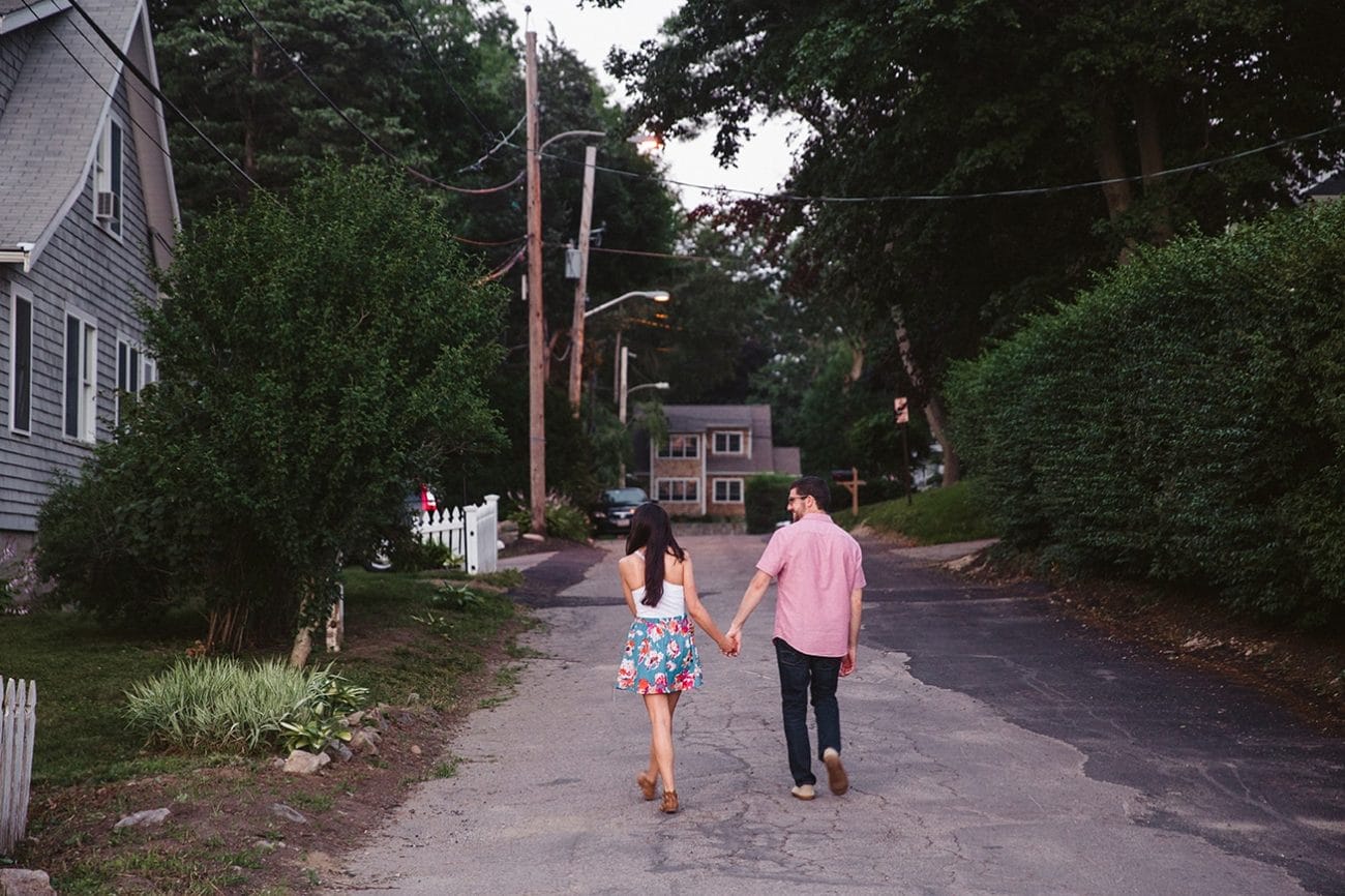 A documentary photograph of a couple walking to their home after their World's End engagement session in Hingham, Massachusetts