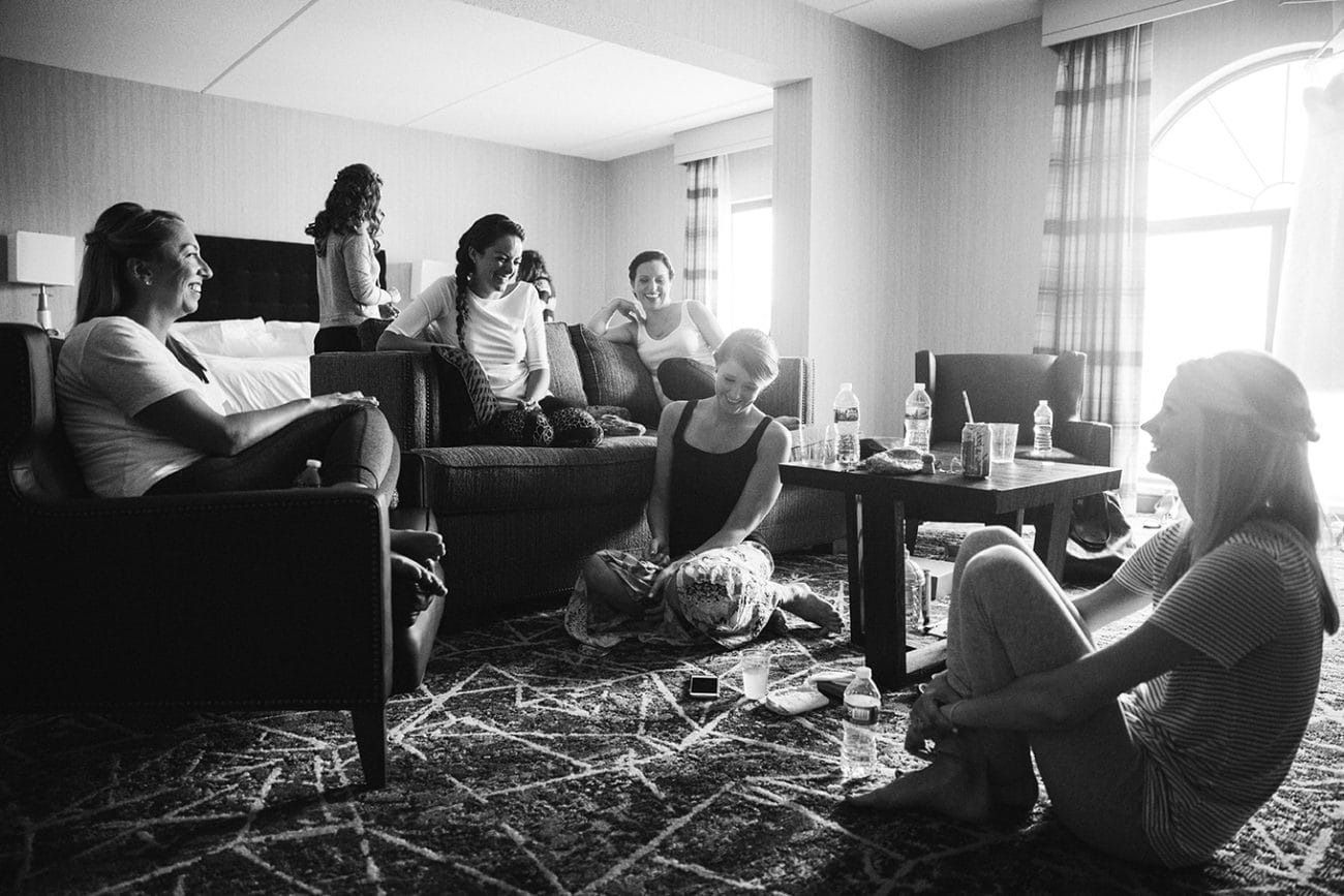 A documentary photograph of a bride laughing with her friends during her plimoth plantation wedding preparations