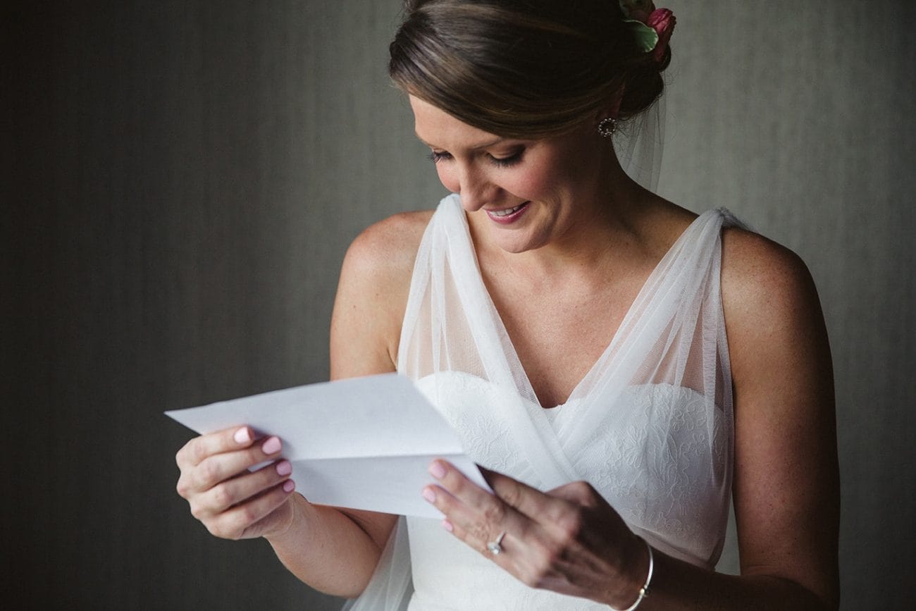 A documentary photograph of a bride reading a letter from the groom before her plimoth plantation wedding in plymouth, massachusetts