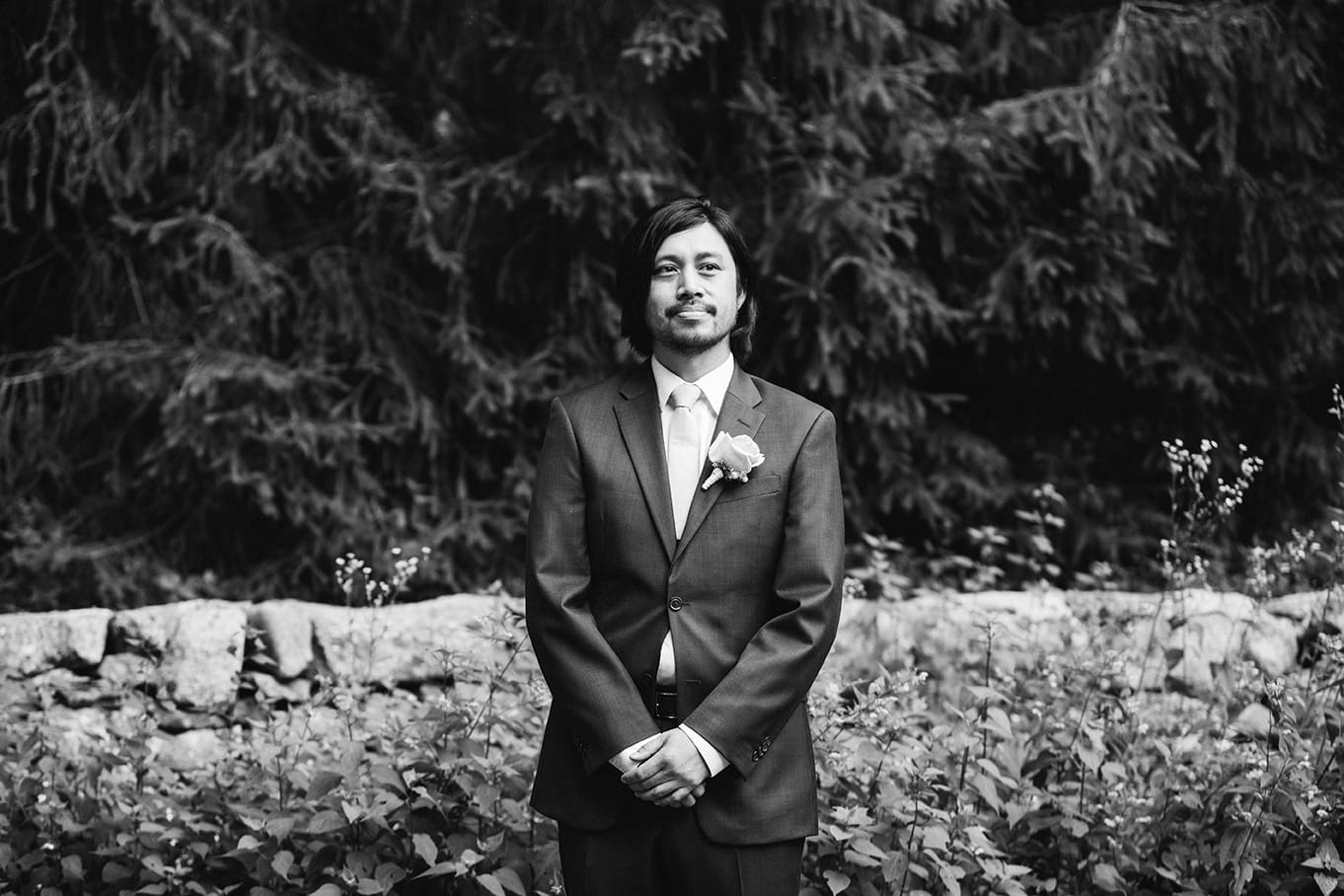 A documentary photograph of a groom waiting for his bride to walk down the aisle during their plimoth plantation wedding in plymouth, massachusetts
