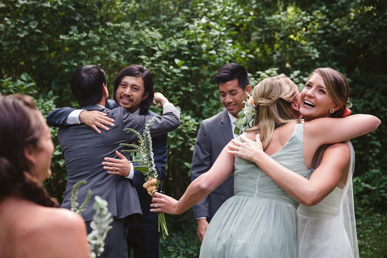 A documentary photograph of a bride and groom hugging their friends moments after their outdoor plimoth plantation wedding ceremony in plymouth, massachusetts