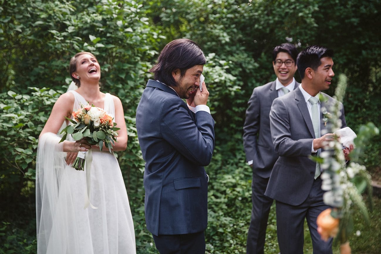 A documentary photograph of a groom wiping away his tears moments after his outdoor plimoth plantation wedding ceremony in plymouth, massachusetts