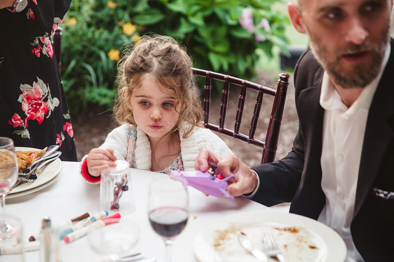 A documentary photograph of a little girl sitting at a plimoth plantation wedding in plymouth, massachusetts