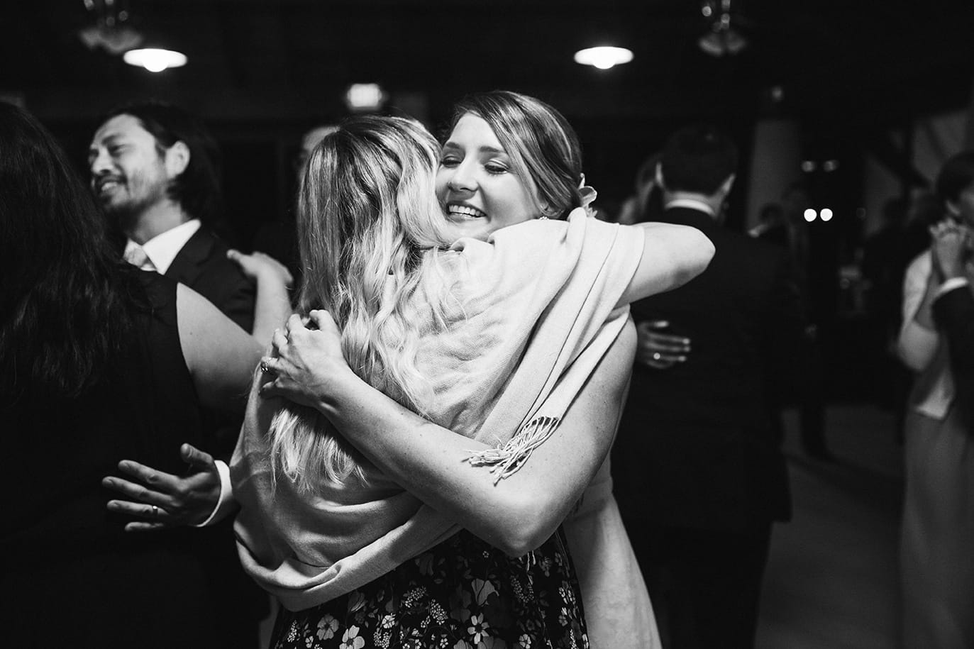A documentary photograph of a bride hugging her friend during a plimoth plantation wedding in plymouth, massachusetts