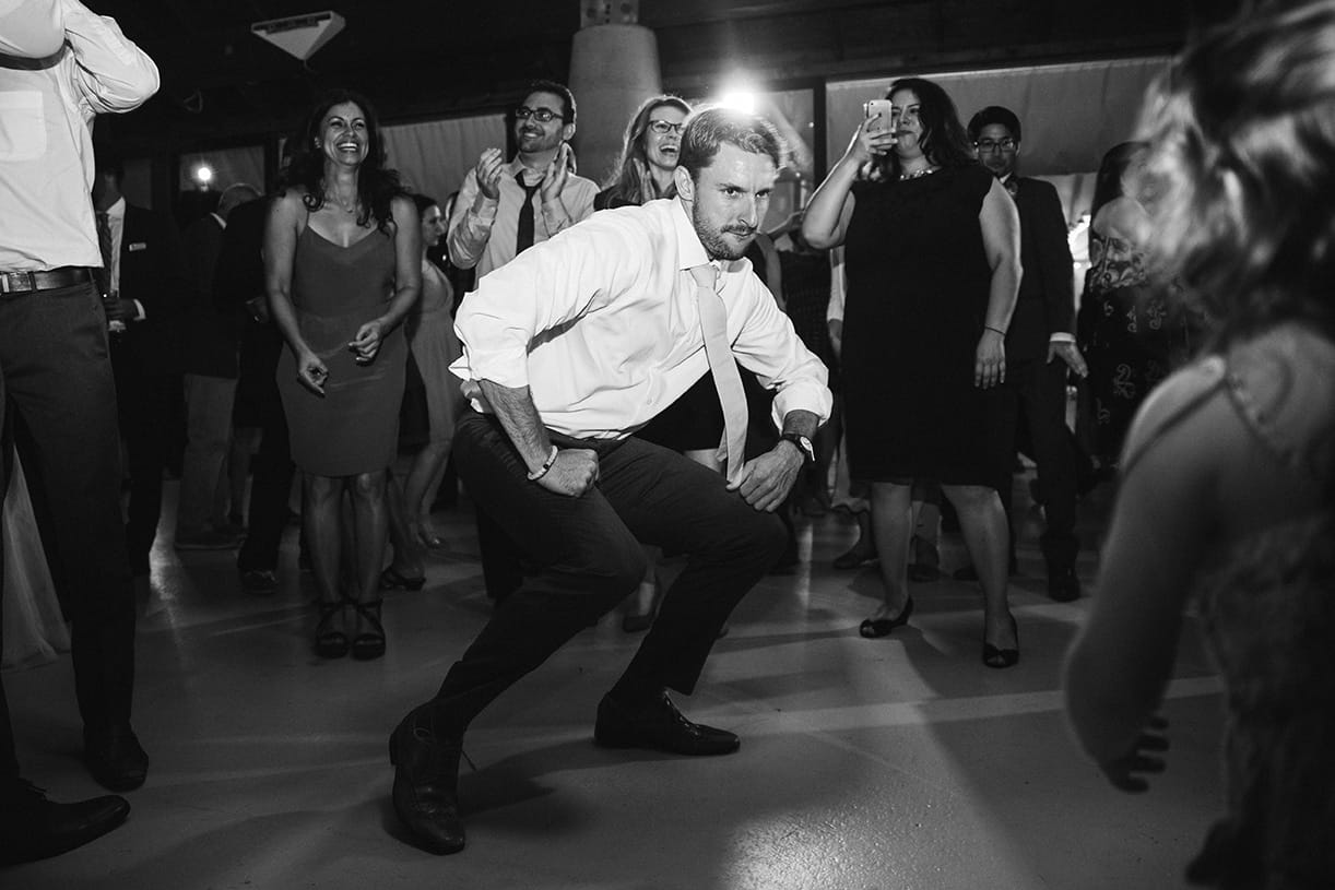 A documentary photograph of groomsman dancing with a little girl during a plimoth plantation wedding in plymouth, massachusetts