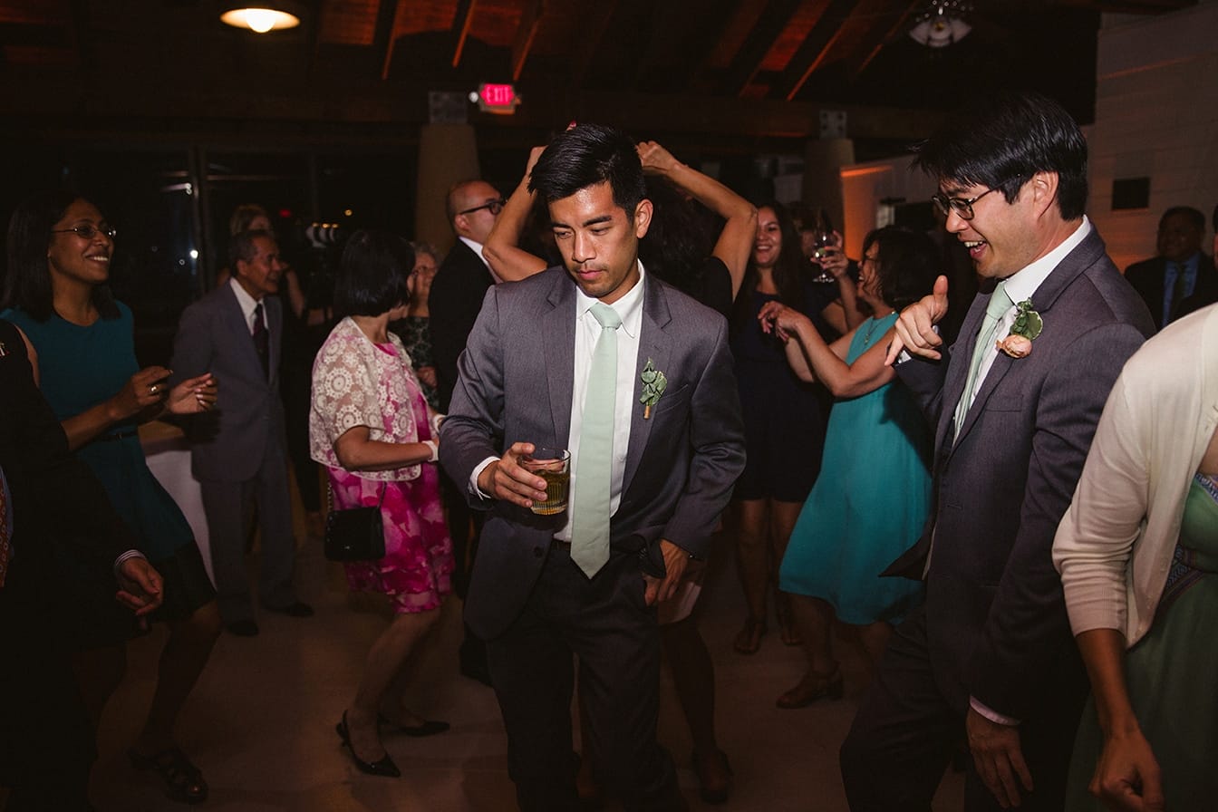A documentary photograph of groomsmen dancing at a plimoth plantation wedding in plymouth, massachusetts