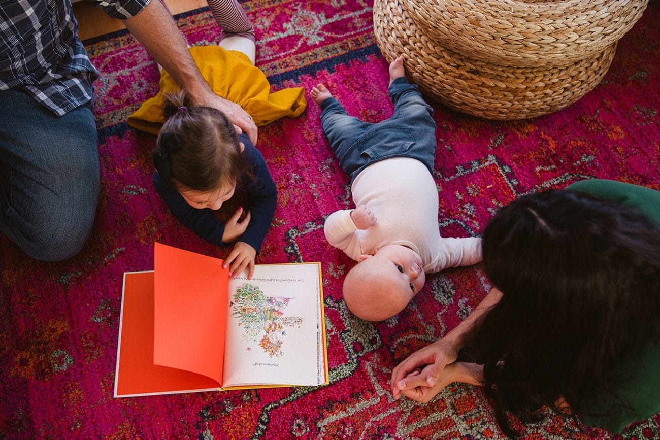 A documentary photograph of a family hanging out and reading books during an in home family lifestyle session in Boston, Massachusetts