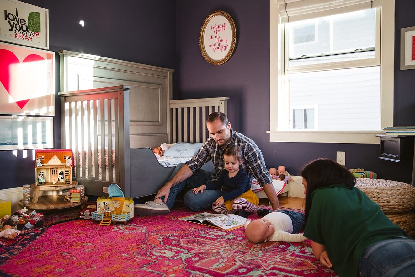 A documentary photograph of a family hanging out and reading books during an in home family lifestyle session in Boston, Massachusetts