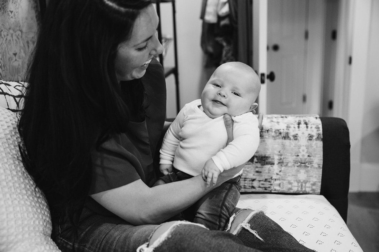 A documentary photograph of a mom holding her baby boy during an in home family lifestyle session in Boston, Massachusetts