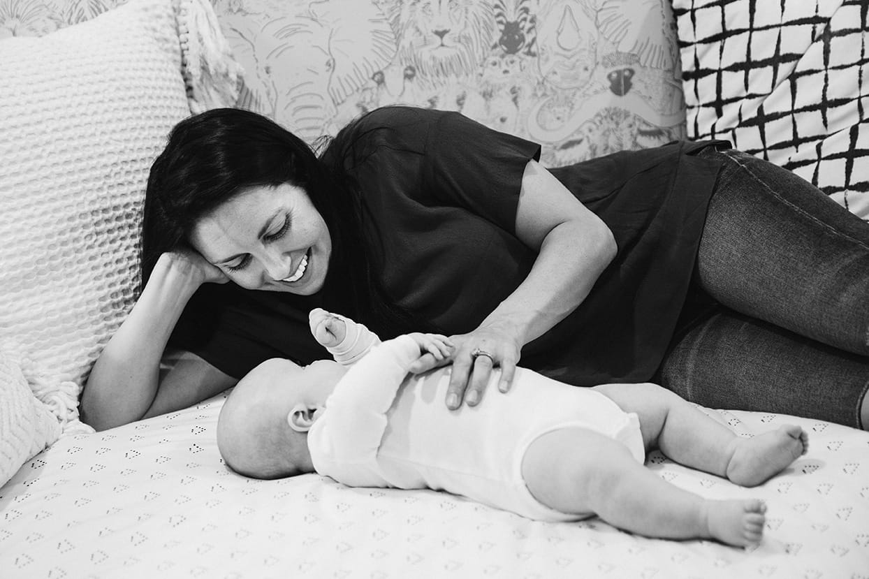 A documentary photograph of mom laying down with her baby boy during an in home family lifestyle session in Boston, Massachusetts