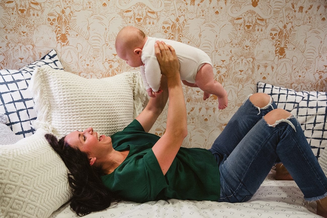 A documentary photograph of a mom playing with her baby boy during an in home family lifestyle session in Boston, Massachusetts