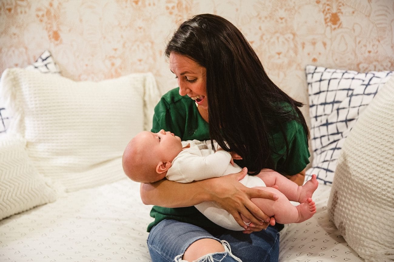 A documentary photograph of a mom holding her baby boy during an in home family lifestyle session in Boston, Massachusetts