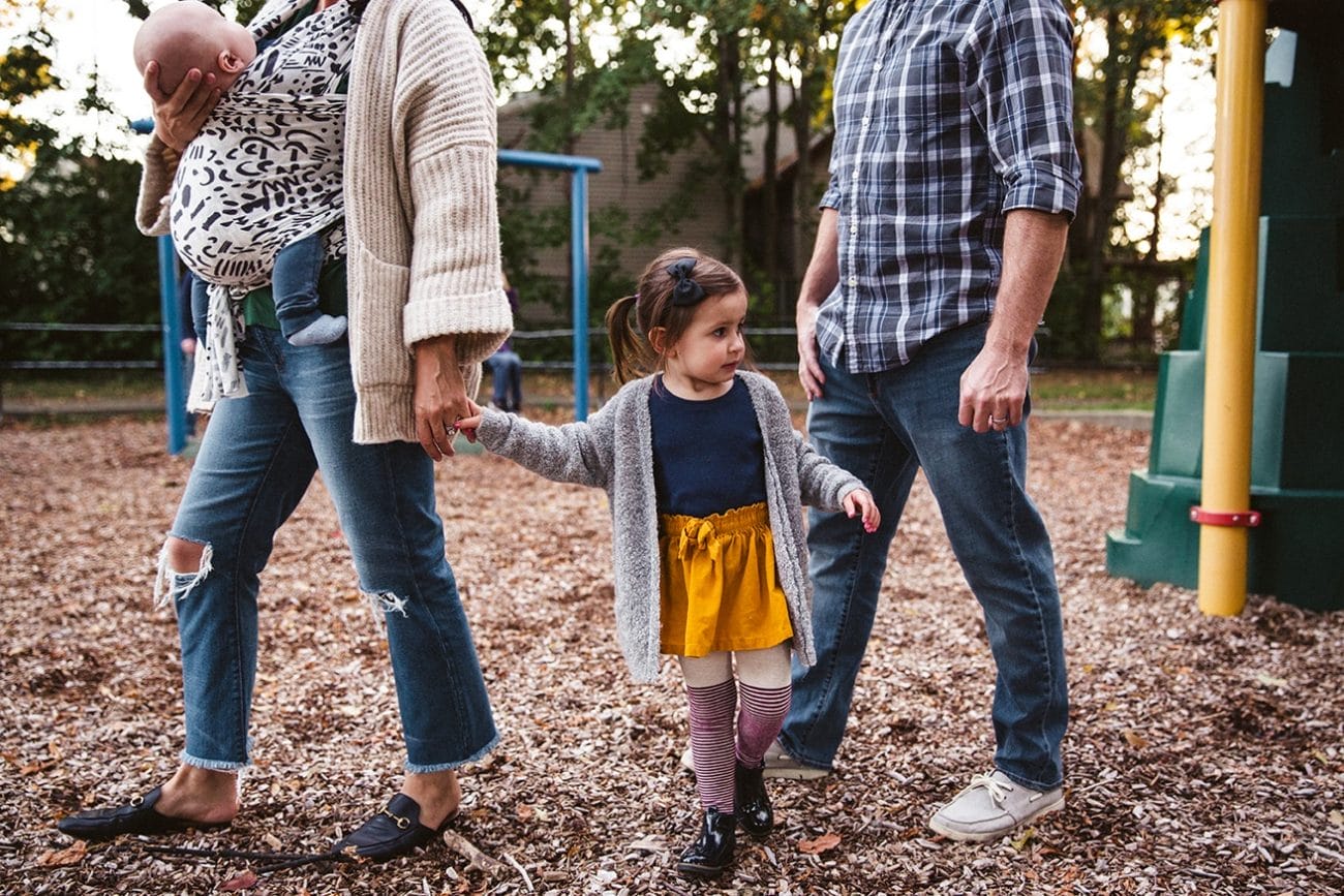 A documentary photograph of a family walking through the playground during a family lifestyle session in Boston, Massachusetts