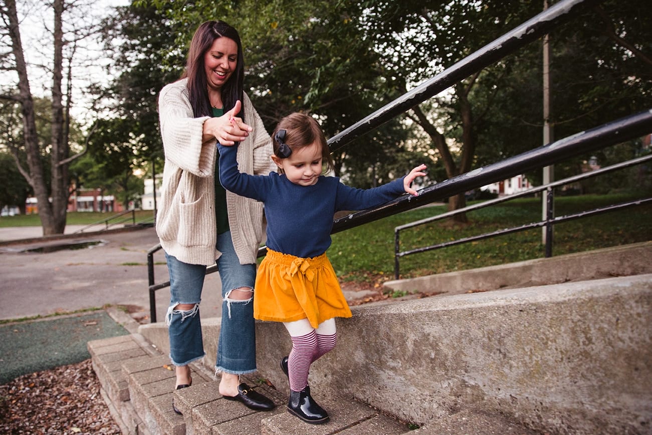 A documentary photograph of a mom and daughter playing together during a family lifestyle session in Boston, Massachusetts