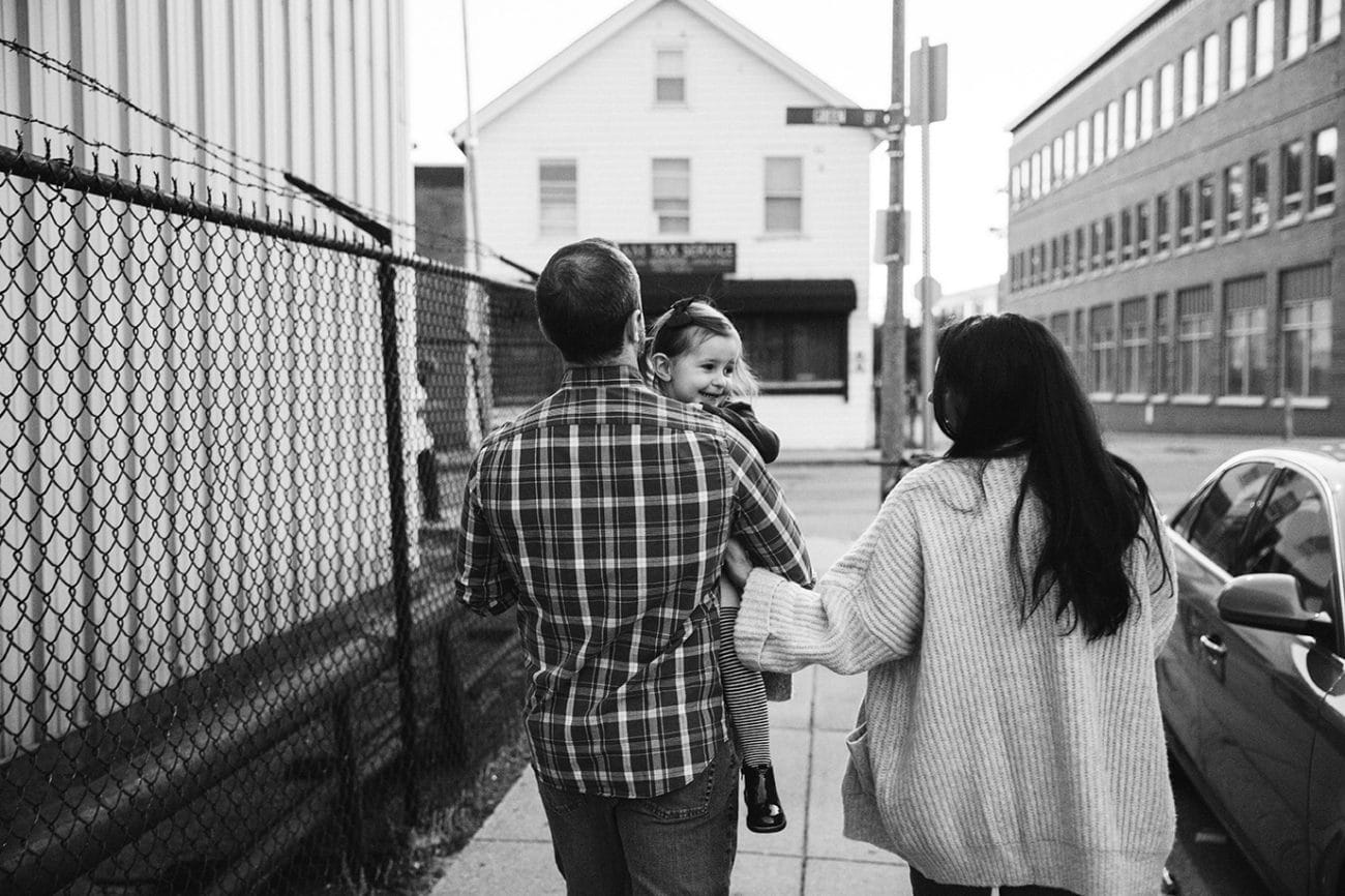 A documentary photograph of a family walking home from the playground together during their family lifestyle session in Boston, Massachusetts