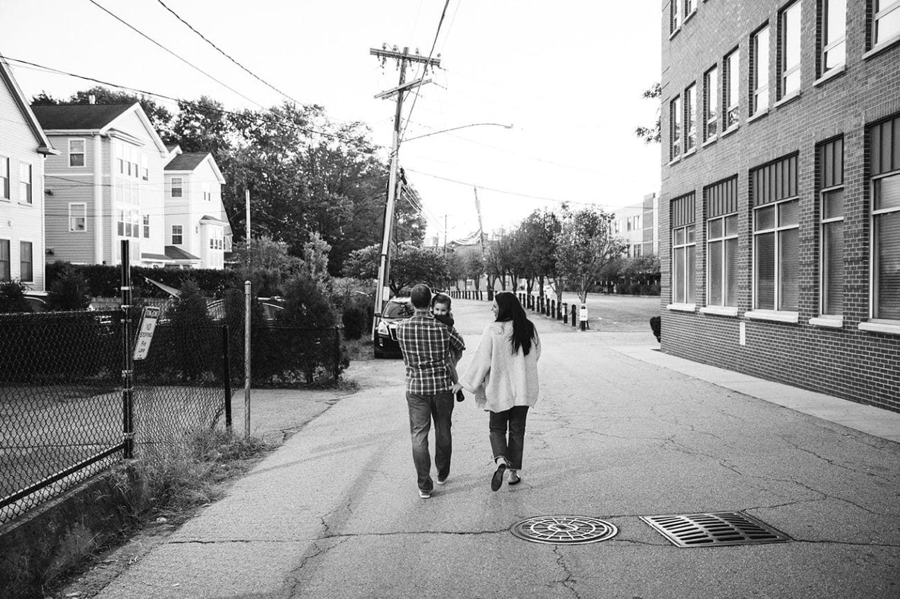 A documentary photograph of a family walking home from the playground together during their in home family session in Boston, Massachusetts