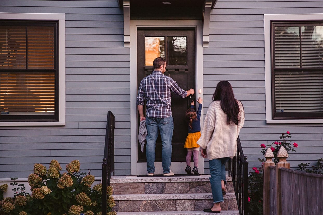 A documentary photograph of a family walking into their home during a family lifestyle session in Boston, Massachusetts