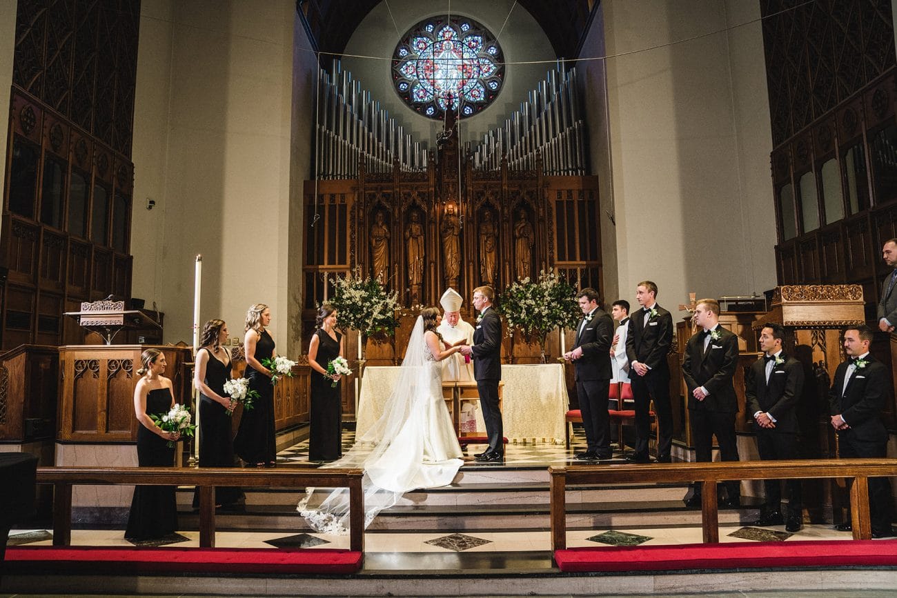 A documentary photograph of bride and groom saying their vows during their Boston Wedding Ceremony at Marsh Chapel