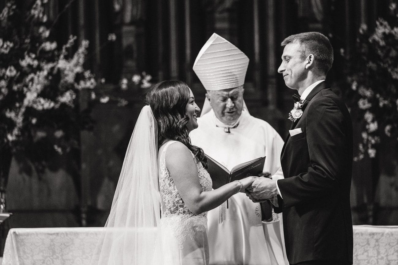 A documentary photograph of the bride and groom saying their vows during a Boston Wedding Ceremony at Marsh Chapel