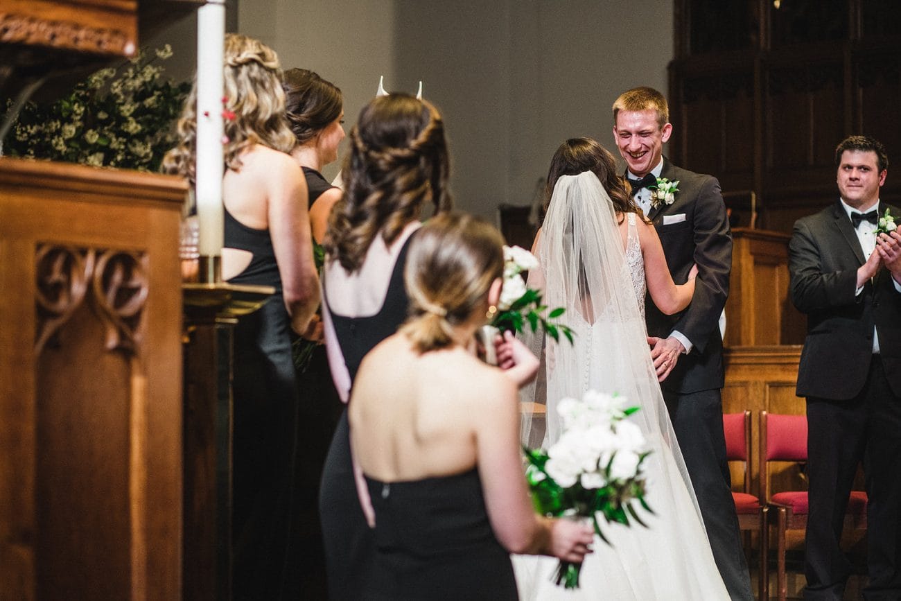 A documentary photograph of groom crying after the vows of their Boston Wedding Ceremony in Marsh Chapel