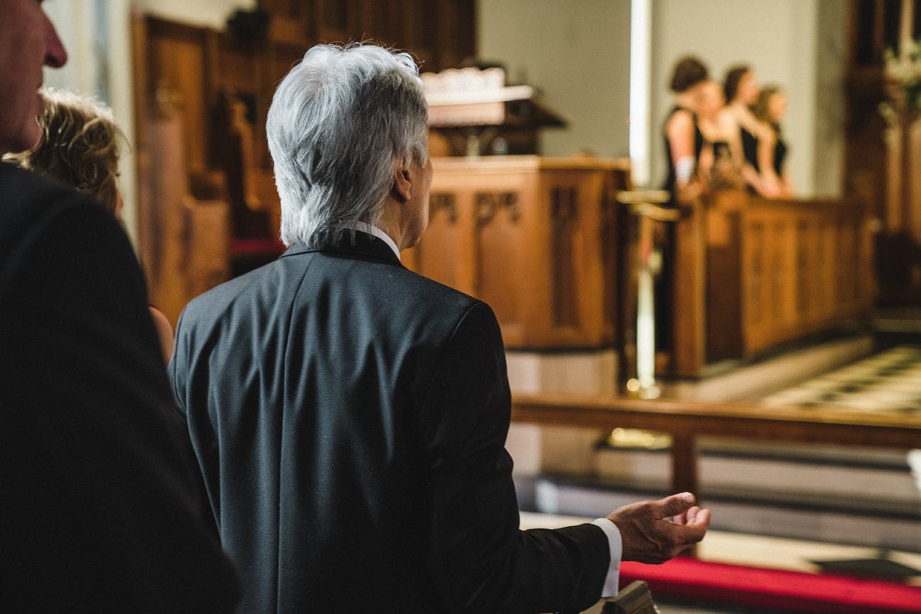 A documentary photograph of guests praying during a Marsh Chapel Wedding Ceremony in Boston