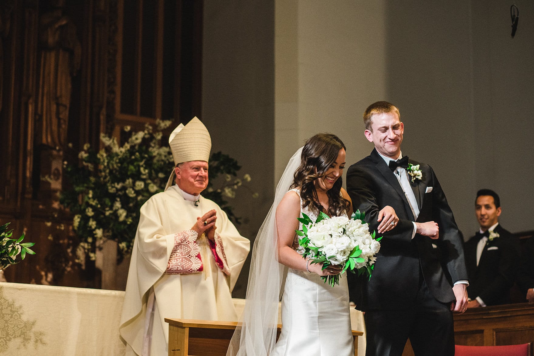 A documentary photograph of the bride and groom before they walk down the aisle of Marsh Chapel during their boston wedding ceremony