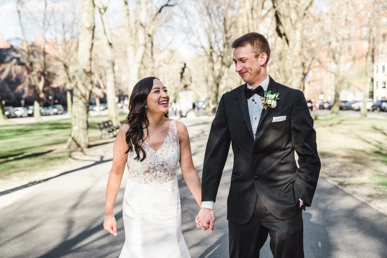 A candid portrait of a bride and groom walking on commonwealth mall in Boston during their Fairmont Copley Wedding