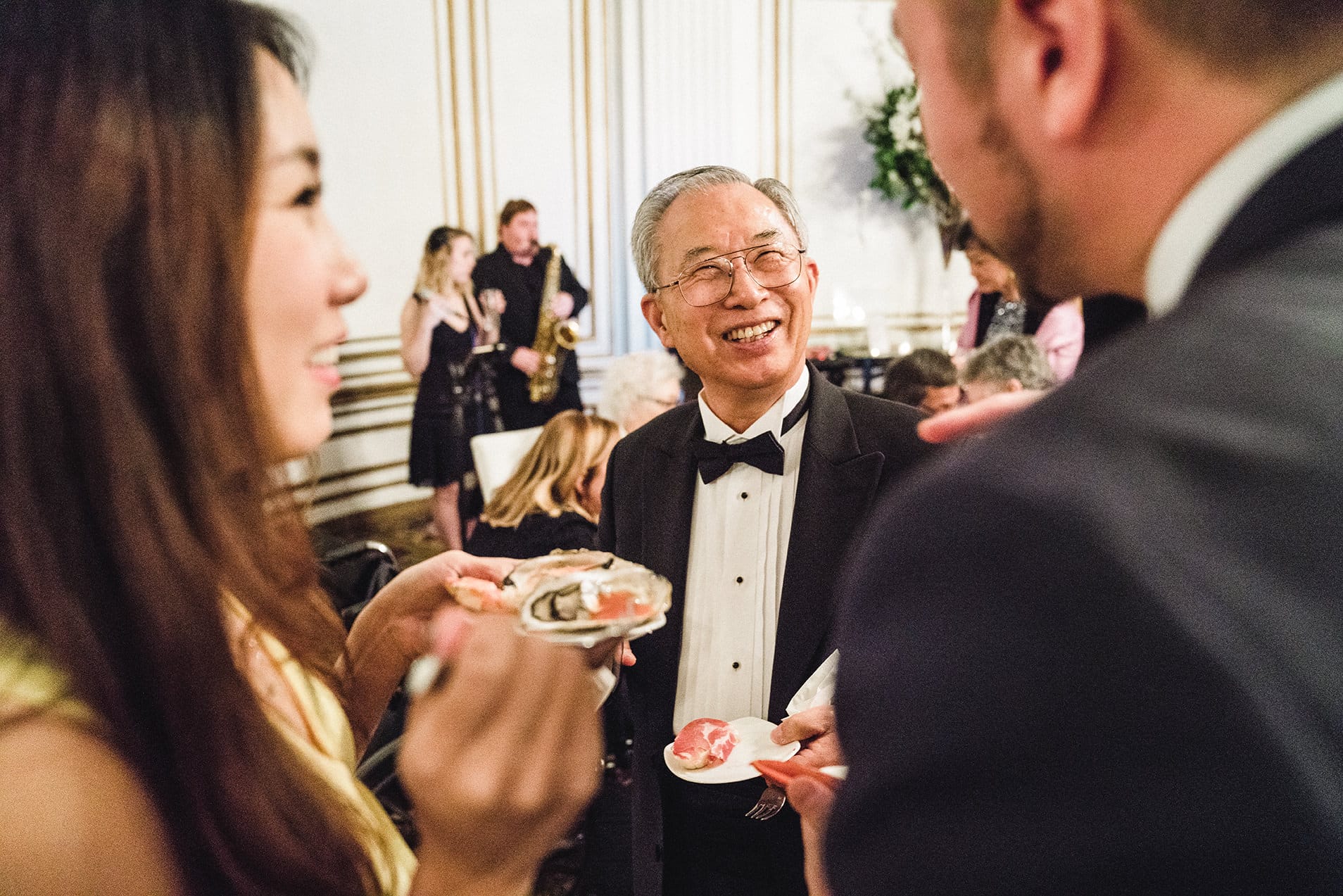 A documentary photograph of guests talking during cocktail hour of a fairmont copley wedding