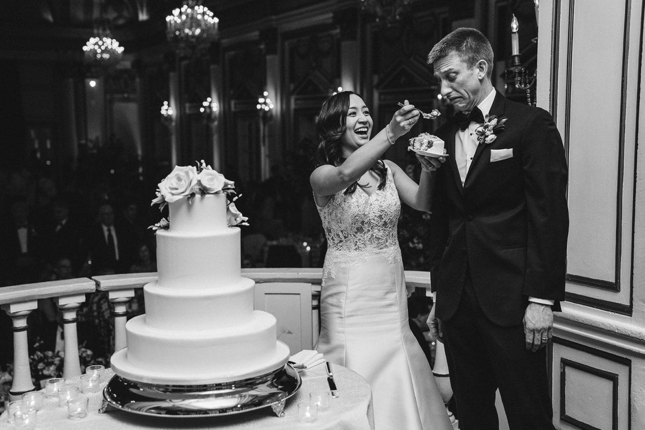 A documentary photograph of the bride and groom cutting the cake at a fairmont copley wedding