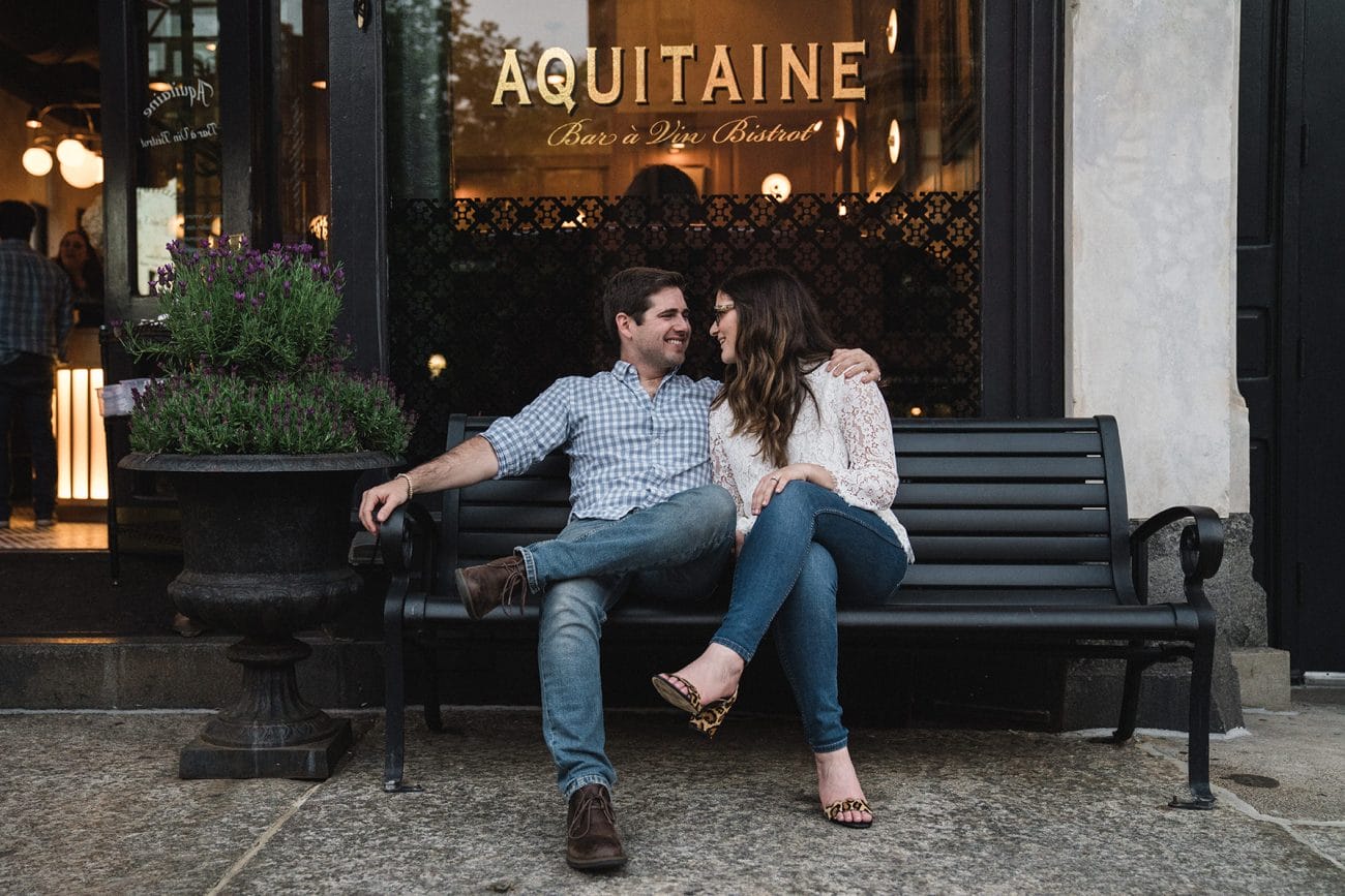 A documentary photograph of a couple sitting and talking outside Aquitaine during their South End Engagement Session