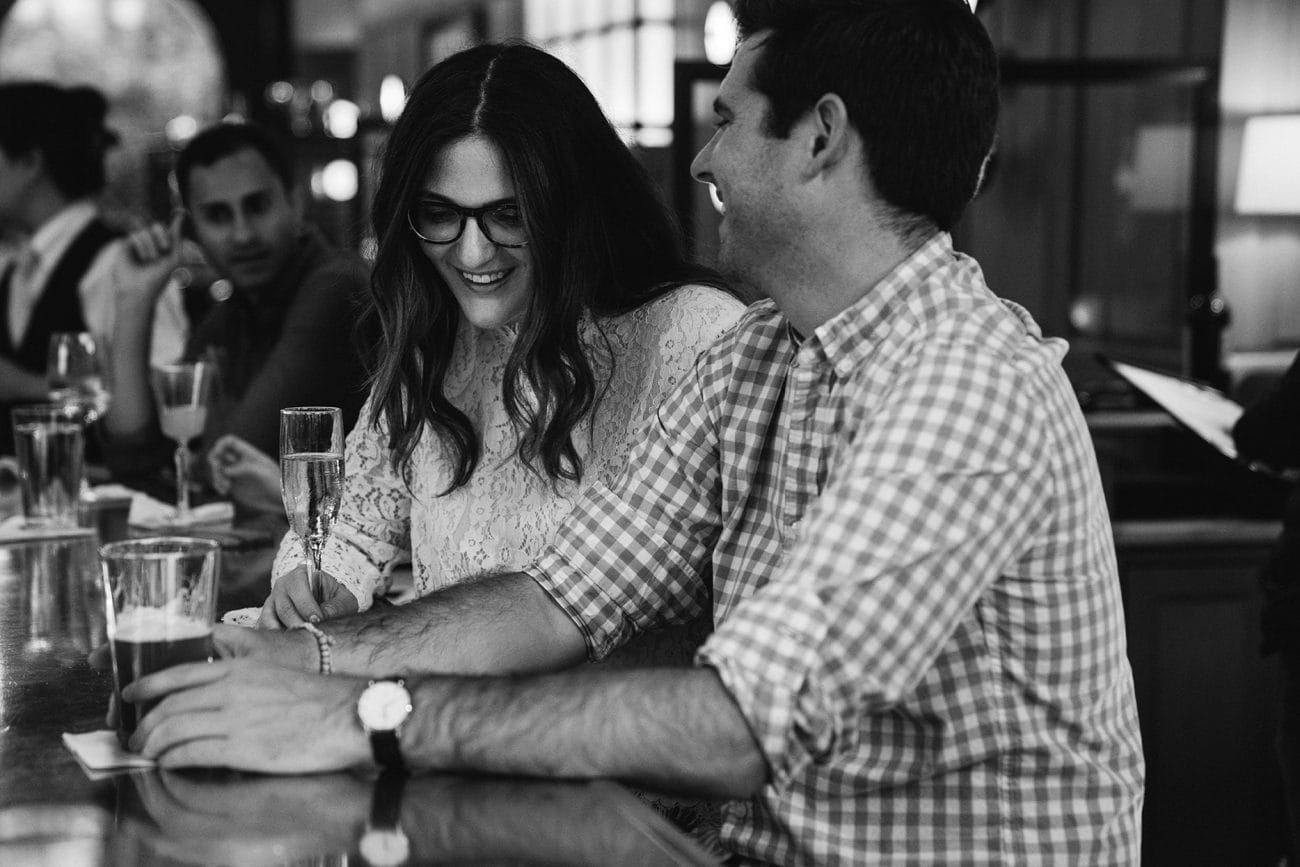 A documentary photograph of a couple laughing at Aquitaine during their South End Boston Engagement Session