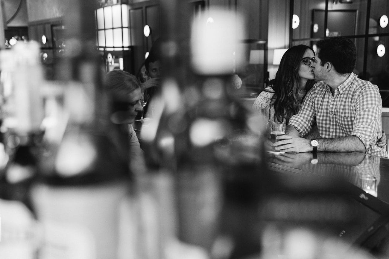 A documentary photograph of a couple kissing at Aquitaine during their South End Boston Engagement Session