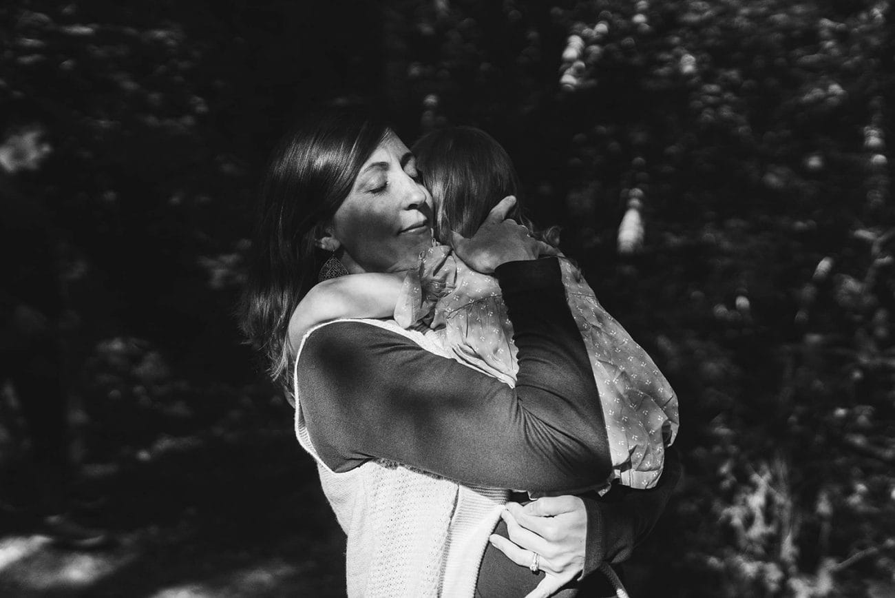 A documentary portrait of a mother hugging her daughter during their family session at Borderland State Park outside of Boston