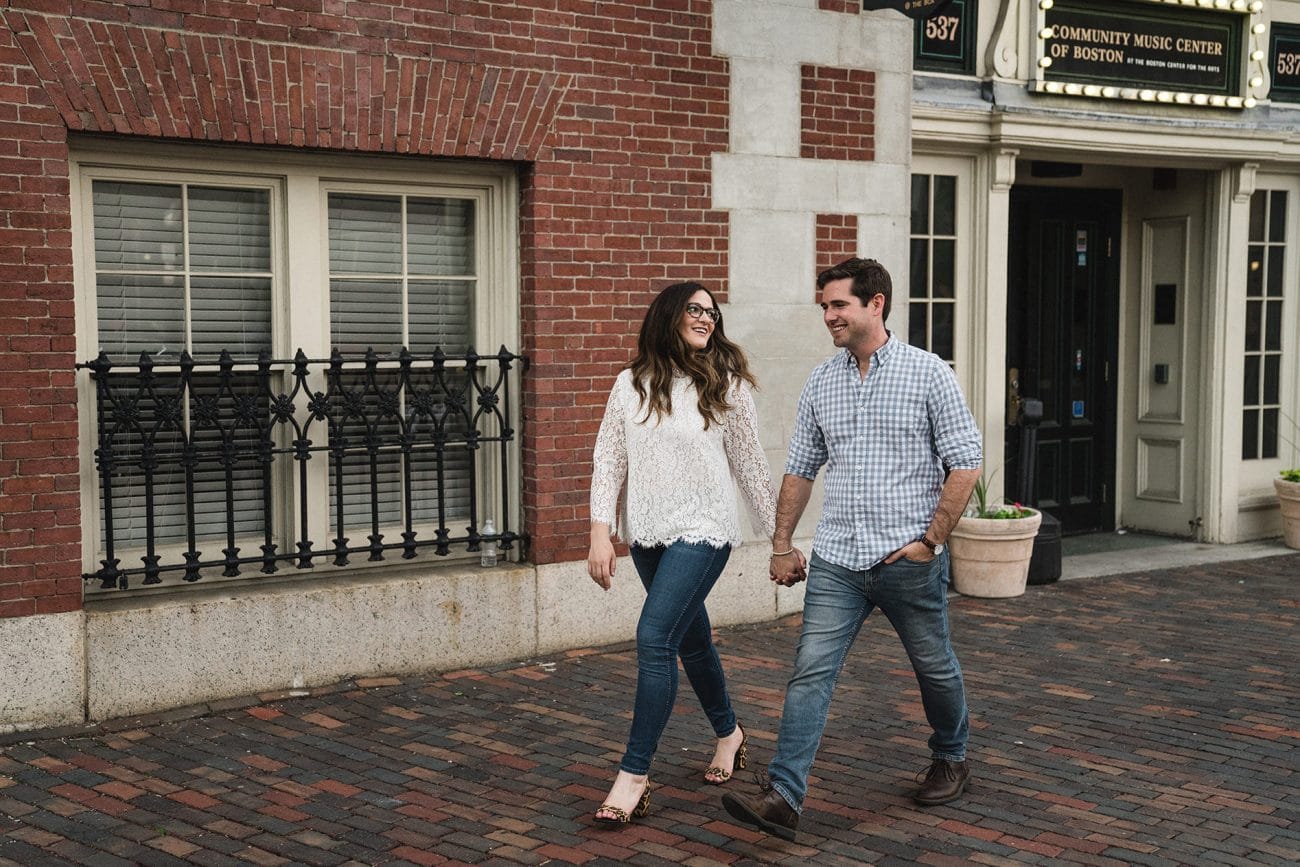 A documentary photograph of a couple walking through the South End during their Boston engagement session