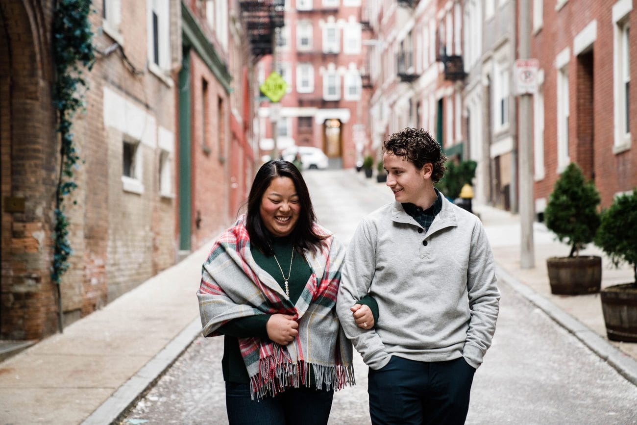 A documentary photograph of a couple walking together during their north end boston engagement session