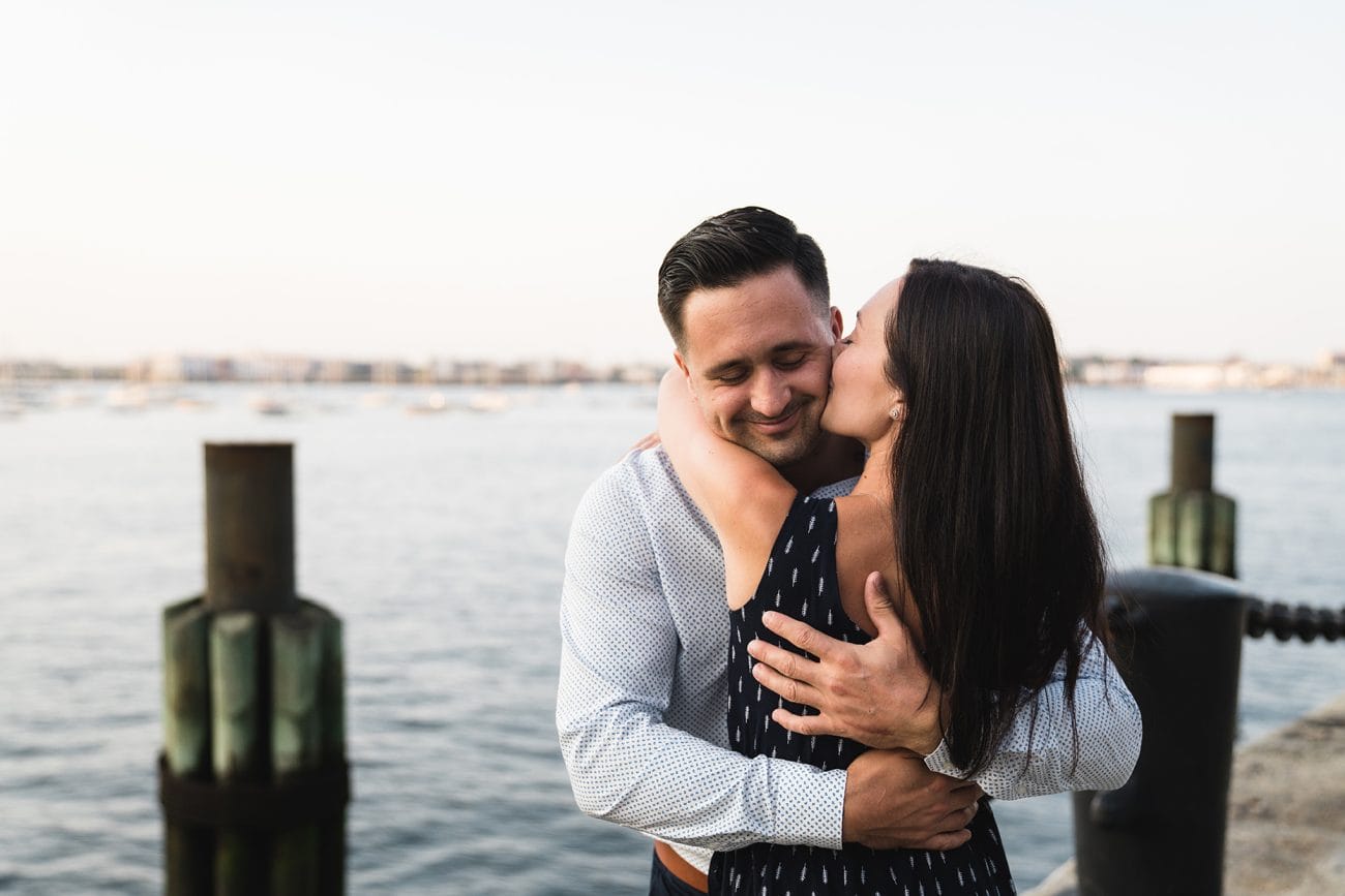 A documentary photograph of a couple hugging during their fan pier engagement session at Boston's seaport 
