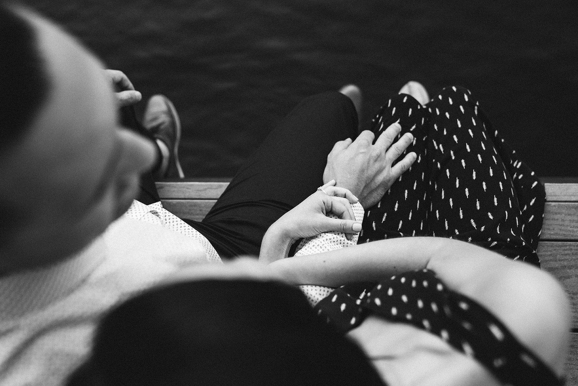 A documentary photograph of a couple holding hands during their boston seaport engagement session at fan pier