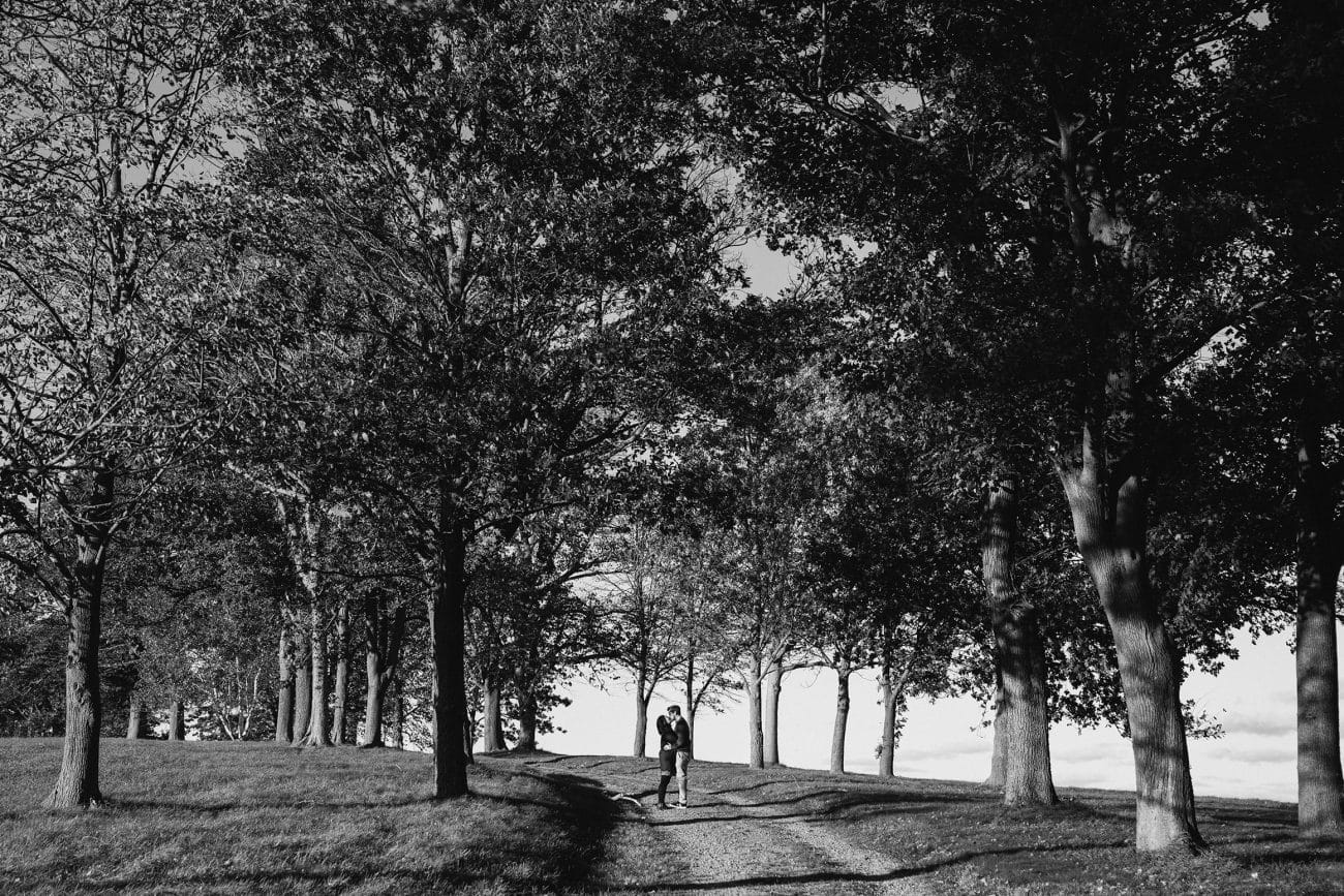 A documentary portrait of couple hugging during their boston engagement session at the world's end