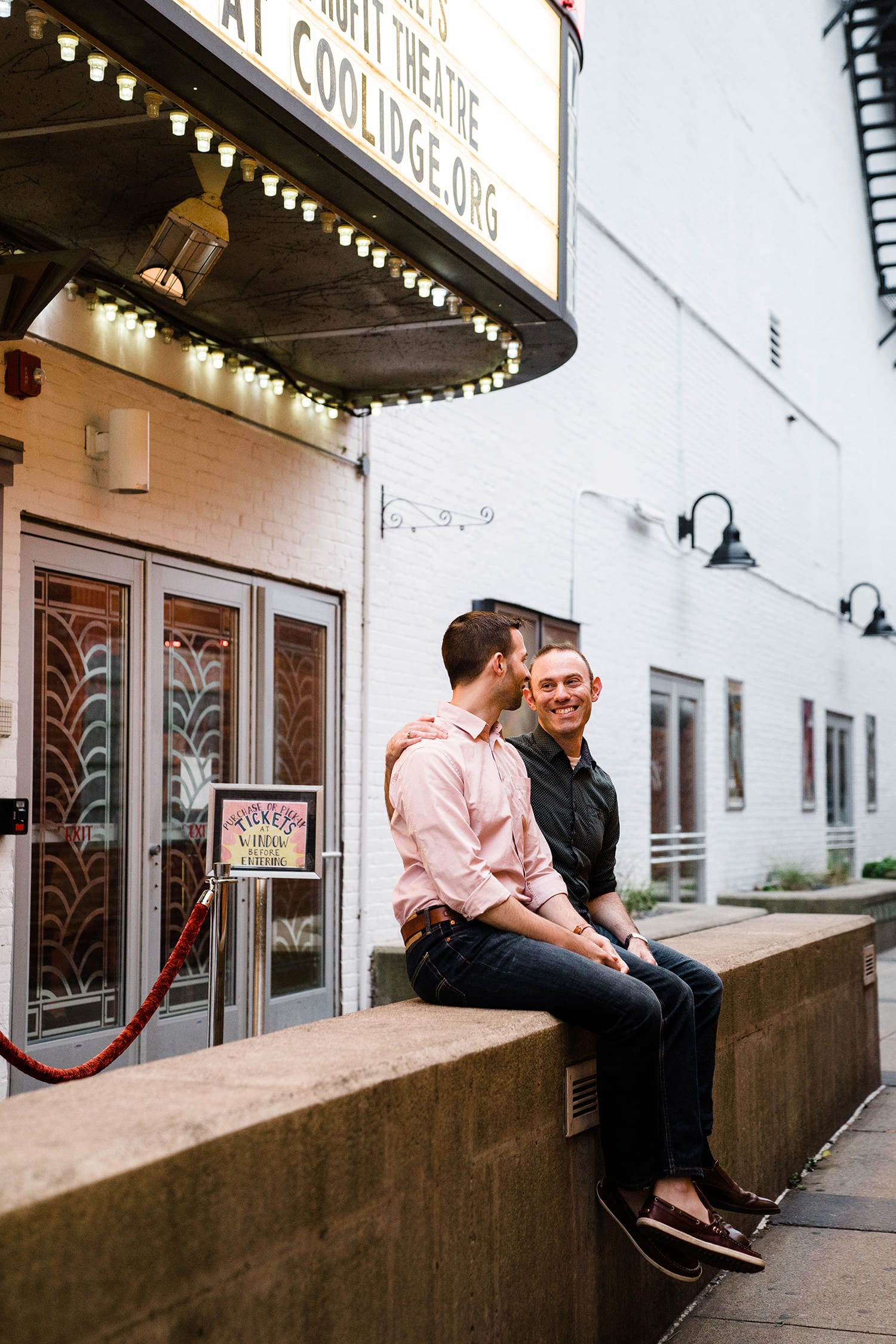 A documentary photograph of a couple hanging out before the movies during their Boston engagement session