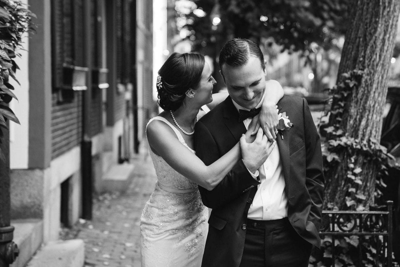 A best of Boston wedding photograph of a couple hugging and laughing during their state room wedding