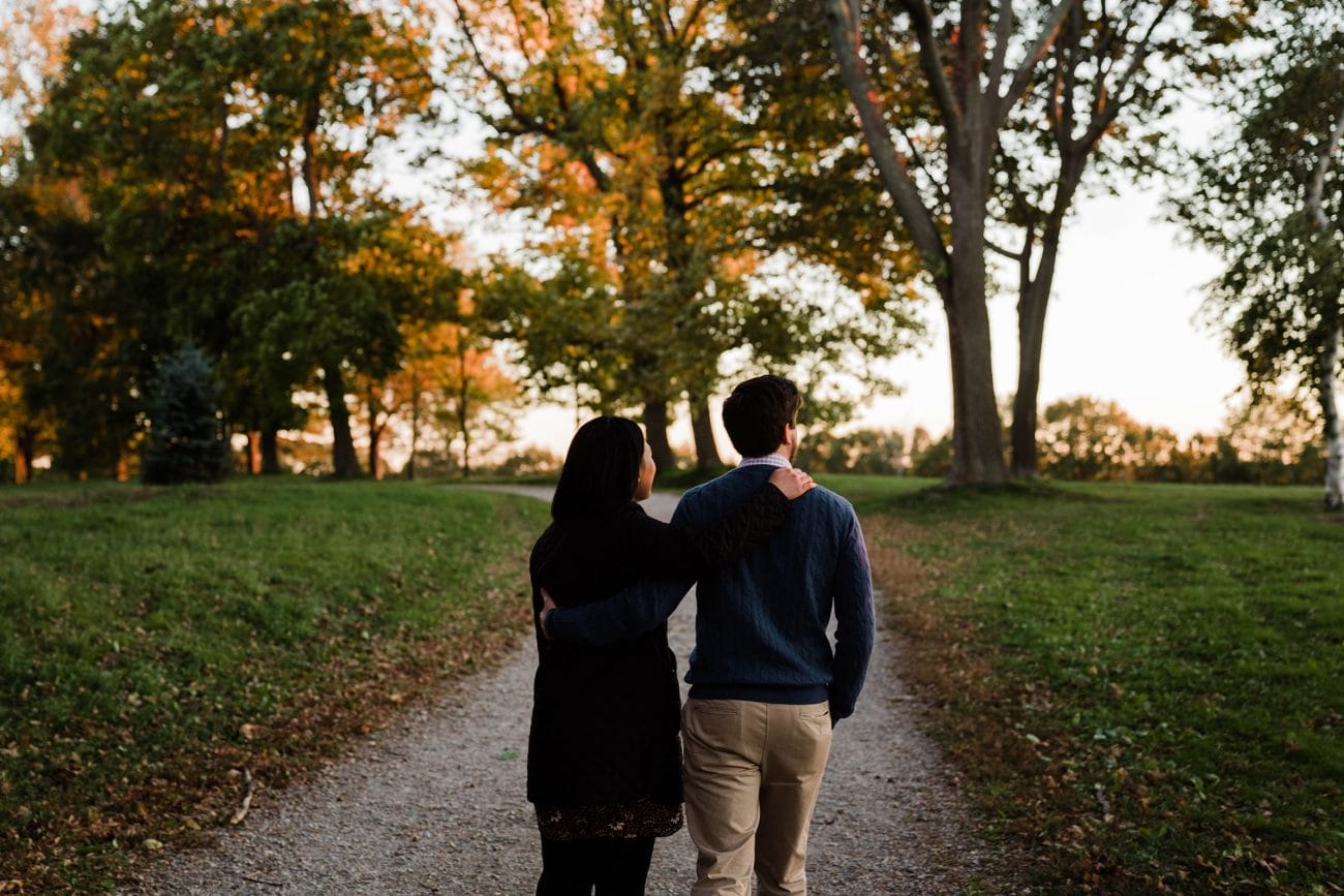 A documentary photograph of a couple walking together during their Boston engagement session at the World's End