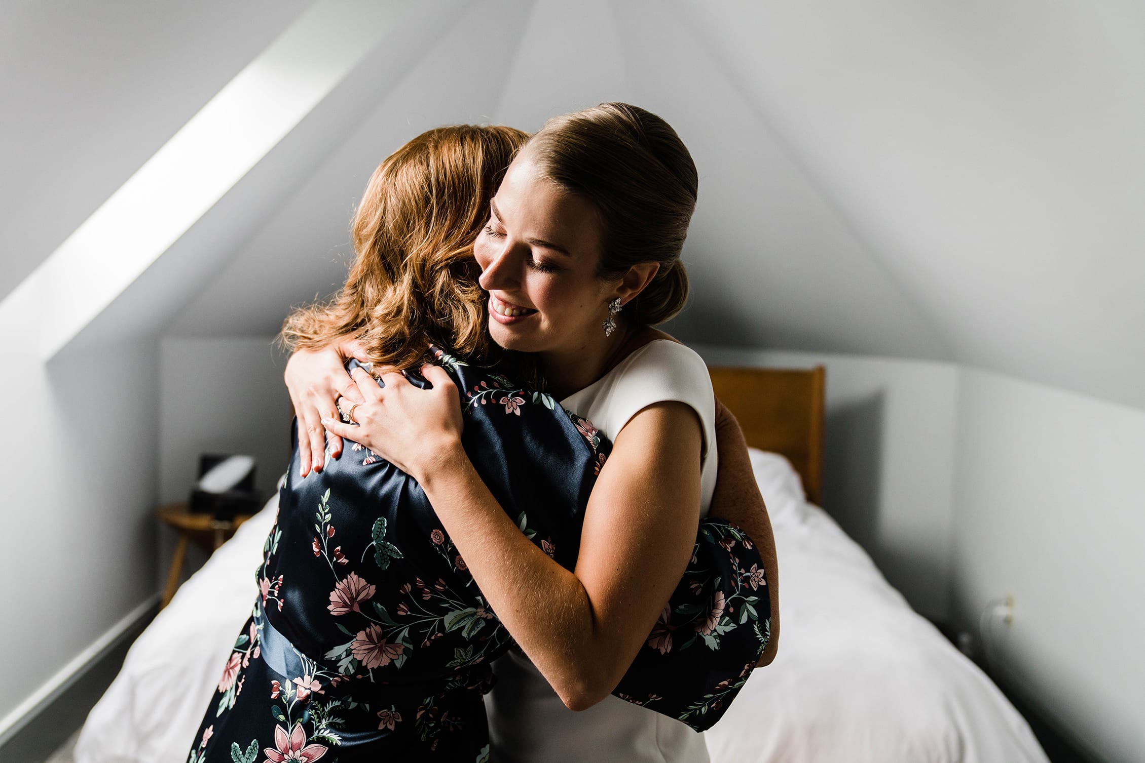 A best of Boston wedding photograph of a bride hugging her mom during the wedding preparations of her Boston wedding