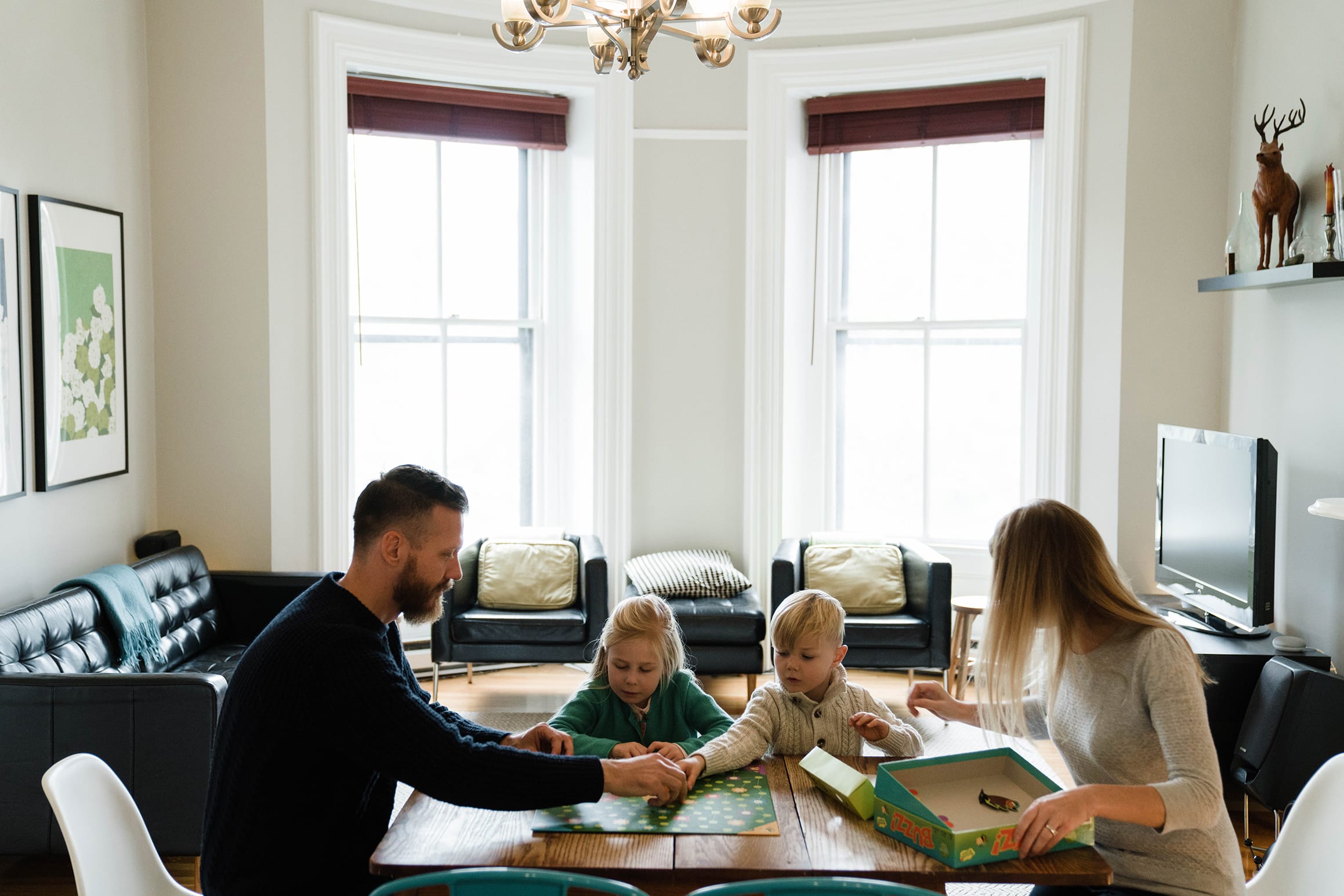 A best of Boston family photograph of a family playing a board game during their in home family session in Boston